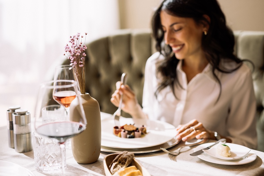Hotel Hohenwart Südtirol – Frau genießt Gourmet-Dessert mit Wein im stilvollen Restaurant
