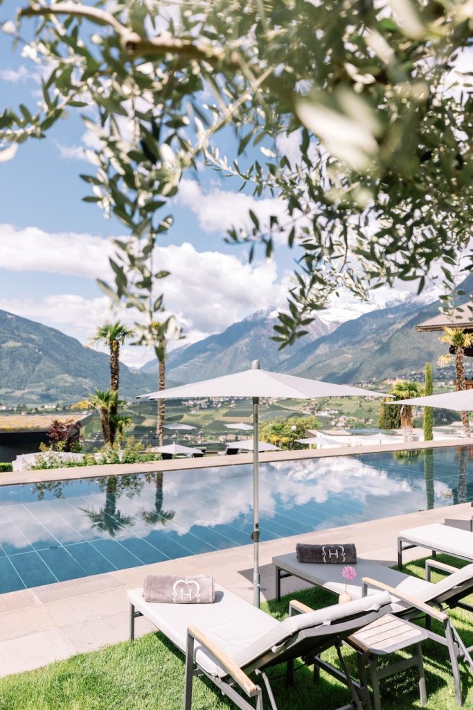 Hotel Hohenwart Südtirol – Outdoor Pool mit Liegen, Sonnenschirmen und Panoramablick über Meran und die Alpen