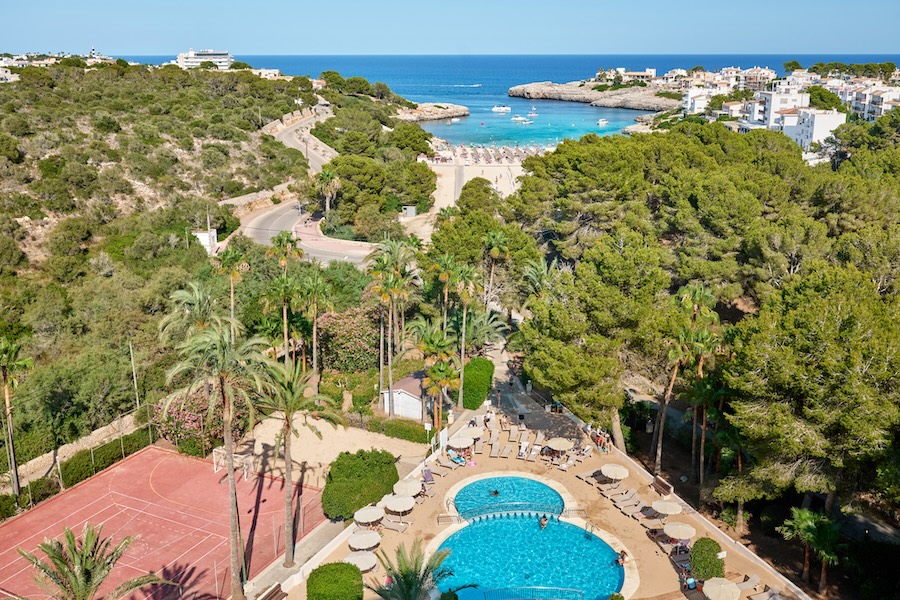 Aussicht vom Balkon des Grupotel Cala Marsal Nature Hotel auf Pinien, Pool und Tennisplatz